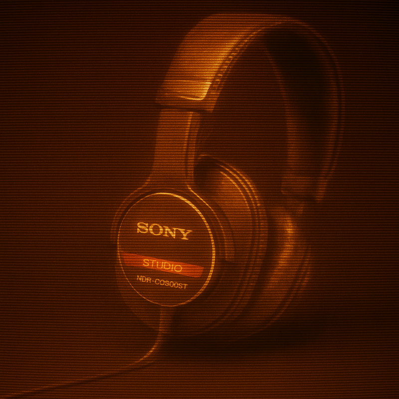 Sony MDR-CD900ST headphones on an amber phosphor CRT display with scanlines